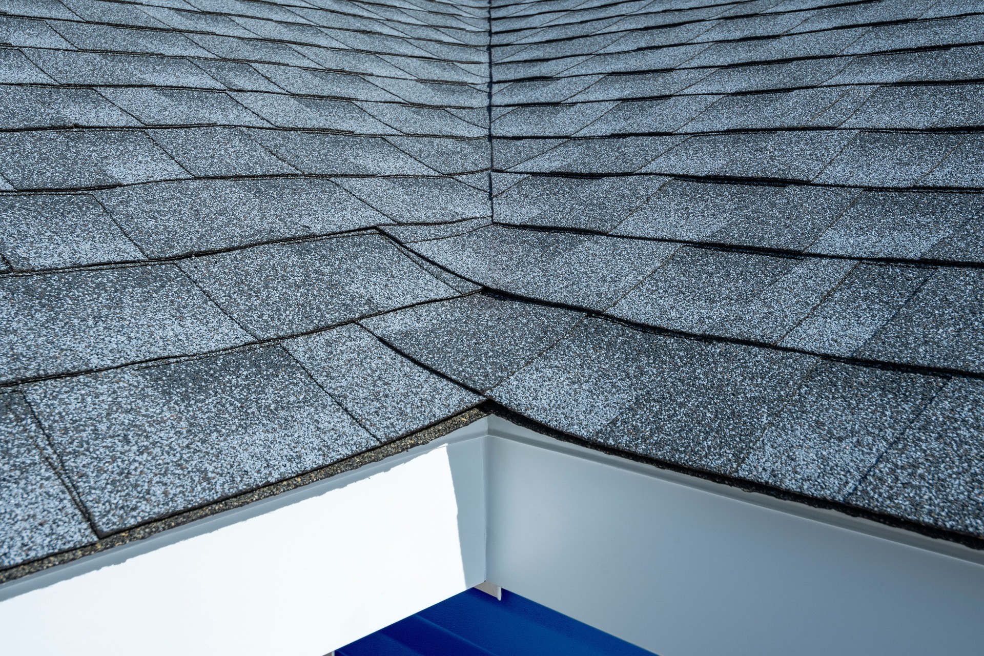 A close-up of newly installed fascia, soffit and asphalt shingles on a residential home